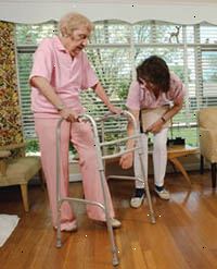 Bilde av en eldre kvinne ved hjelp av en rullator under en fysisk terapi økt