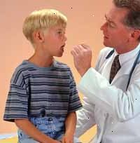 Bilde av en lege undersøker en ung gutt