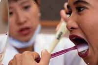 Bilde av en tannlege instruere en ung jente på skikkelig tannpuss teknikker
