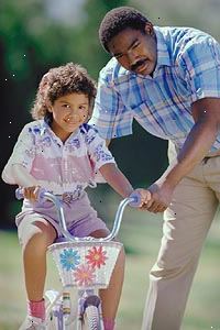 Bilde av en far lærer sin datter å sykle