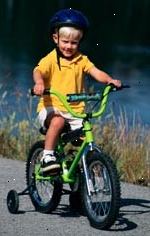 Bilde av ung gutt, med en hjelm, sykler
