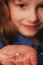 Bilde av en ung jente som holder en tann