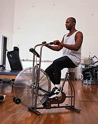 Bilde av en mann trener på en ergometersykkel