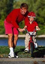 Bilde av en far lærer sin unge sønn hvordan å sykle