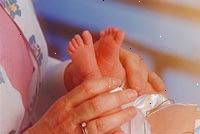 Bilde av en sykepleier undersøker en nyfødt