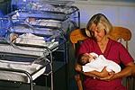 Bilde av en sykepleier som holder en baby på sykehuset barnehage