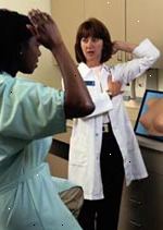 Bilde av en kvinnelig lege undervisning en pasient hvordan å utføre en selv bryst eksamen