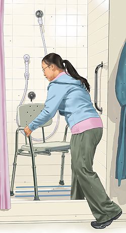 Kvinne å sette dusjstol i dusjnisje. En grab bar er på veggen. Dusjen er en håndholdt tvannsdysen.